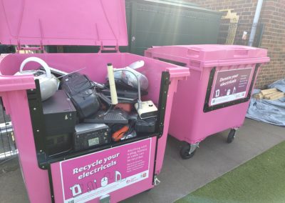 Two pink e-waste bins with e-waste in